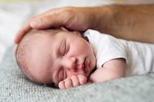 Paternity leave father caressing his cute little newborn baby boy