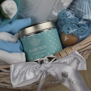 Baby boy candle in the baby clothing hamper