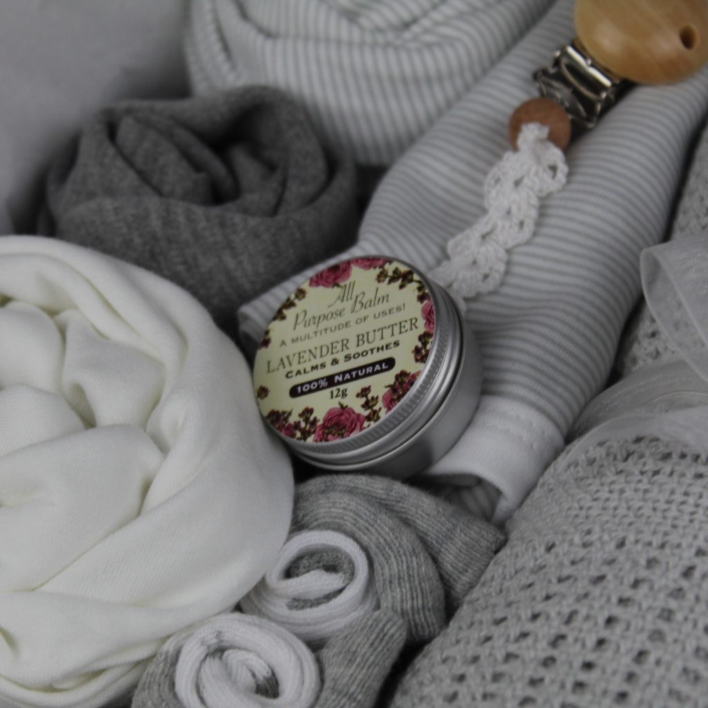 Grey baby clothes in a gift box with magnetic lid